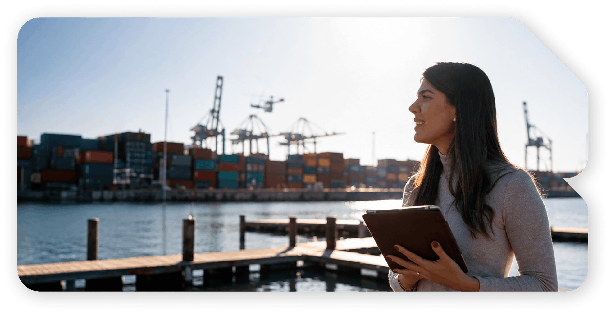 Profesional utilizando una tablet frente a un puerto de contenedores